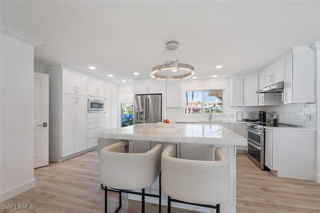 418 Germain Ave, Naples, FL 34108 - kitchen featuring stainless steel appliances, under cabinet range hood, backsplash, healthy amount of natural light, and recessed lighting