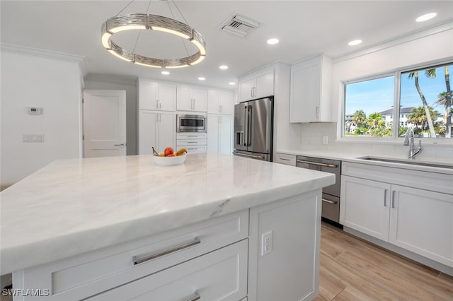 418 Germain Ave, Naples, FL 34108 - kitchen featuring stainless steel appliances, a sink, white cabinetry, recessed lighting, and backsplash