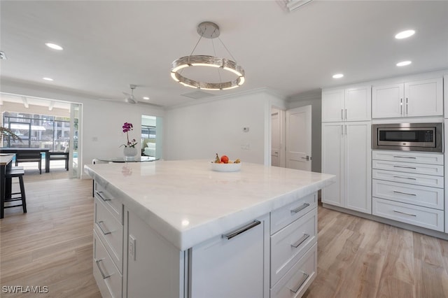 418 Germain Ave, Naples, FL 34108 - kitchen featuring stainless steel microwave, recessed lighting, light wood finished floors, white cabinetry, and a center island