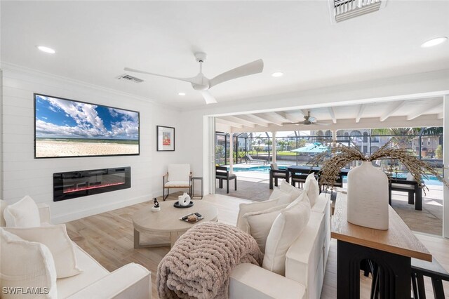 418 Germain Ave, Naples, FL 34108 - living room with ceiling fan, recessed lighting, a glass covered fireplace, wood finished floors, and beam ceiling