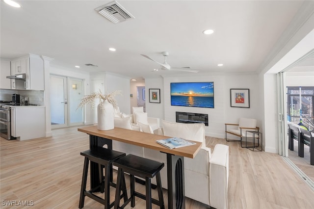 418 Germain Ave, Naples, FL 34108 - dining room with ornamental molding, recessed lighting, a fireplace, light wood-type flooring, and a ceiling fan