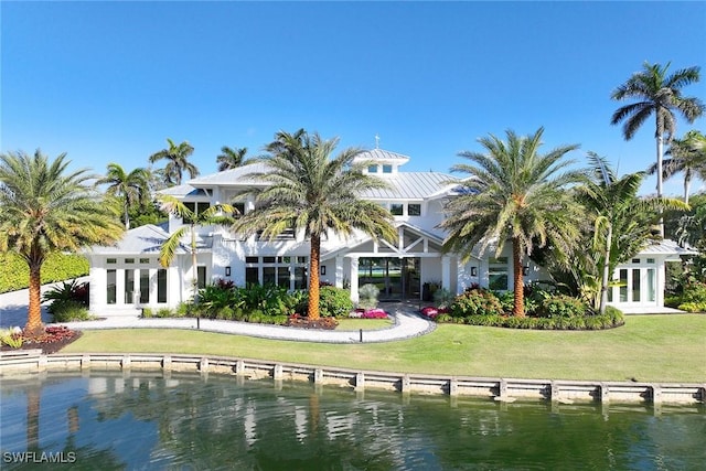 back of property with a yard and a water view