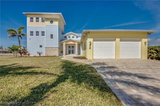 view of front of house featuring a garage, french doors, and a front yard