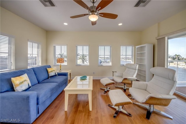 living room featuring light hardwood / wood-style flooring and ceiling fan