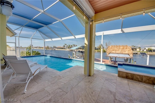 view of pool with a patio area, a water view, and glass enclosure