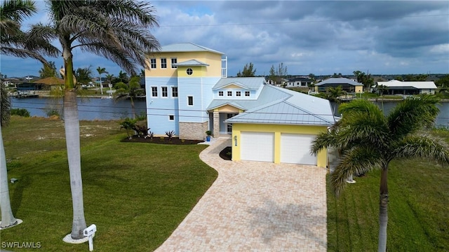 view of front of property featuring a water view, a front lawn, and a garage