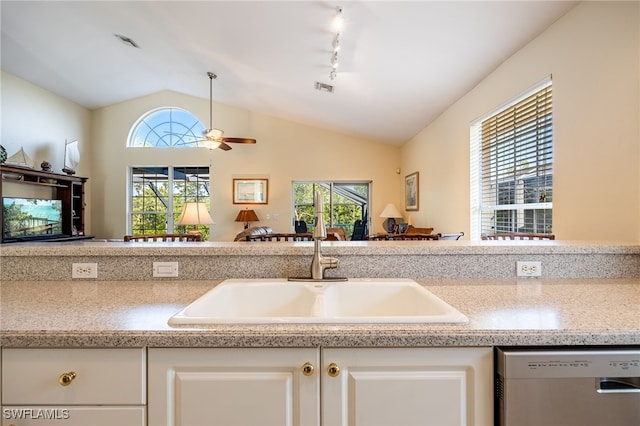 12206 Siesta Dr, Fort Myers Beach, FL 33931 - kitchen featuring stainless steel dishwasher, vaulted ceiling, healthy amount of natural light, a ceiling fan, and white cabinetry