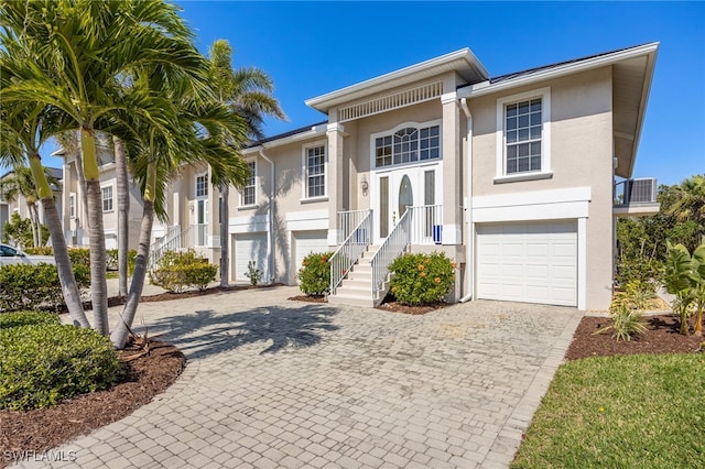 12206 Siesta Dr, Fort Myers Beach, FL 33931 - view of front of home with stucco siding, decorative driveway, a garage, and stairway