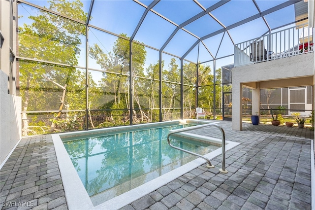 view of pool with a patio and glass enclosure