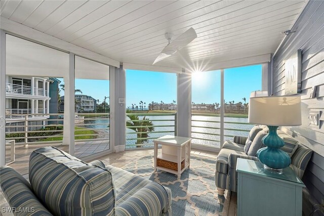 sunroom with a water view, wooden ceiling, and a ceiling fan