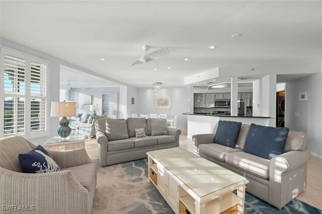 living room with stacked washer and dryer, tile patterned flooring, and recessed lighting