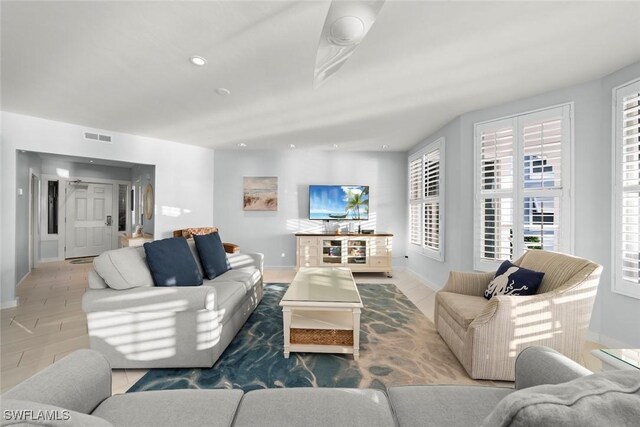 living area featuring recessed lighting, visible vents, and baseboards