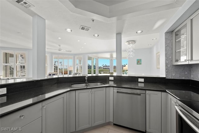 kitchen featuring visible vents, stainless steel appliances, a sink, and gray cabinetry