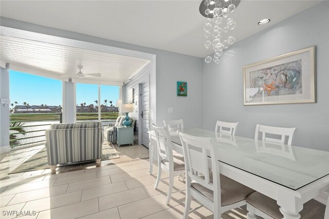 dining room featuring light tile patterned floors, expansive windows, and ceiling fan with notable chandelier