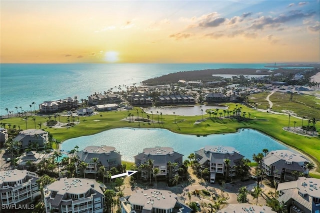 birds eye view of property with view of golf course and a water view