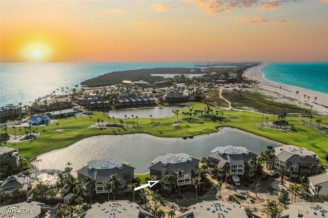 drone / aerial view featuring golf course view and a water view