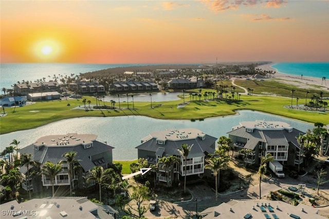 drone / aerial view with a water view and golf course view