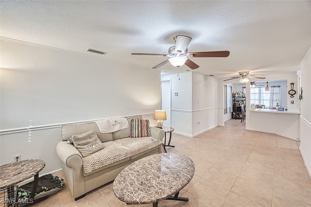 sitting room featuring a textured ceiling, ceiling fan, and visible vents