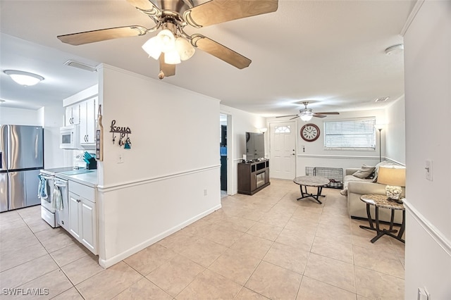 interior space featuring white cabinetry, light tile patterned flooring, stainless steel appliances, and ceiling fan