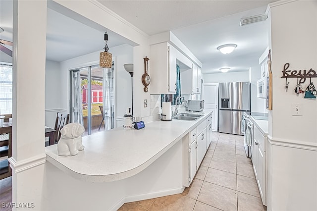 kitchen featuring a sink, stainless steel fridge, stove, light tile patterned floors, and visible vents