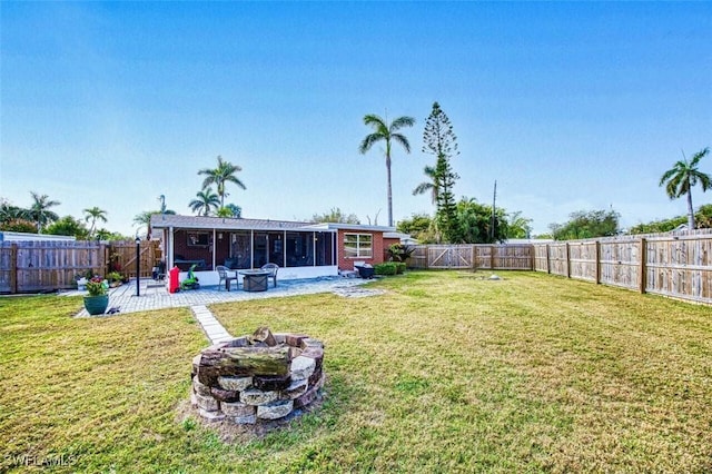 view of yard with an outdoor fire pit, a fenced backyard, a sunroom, and a patio area