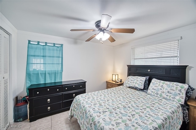tiled bedroom featuring a ceiling fan