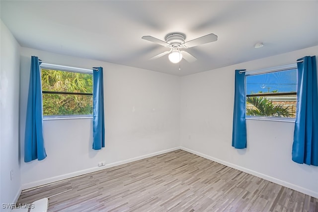 spare room featuring baseboards, wood finished floors, and ceiling fan