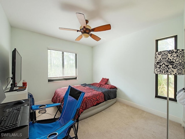 bedroom featuring baseboards, a ceiling fan, and light colored carpet