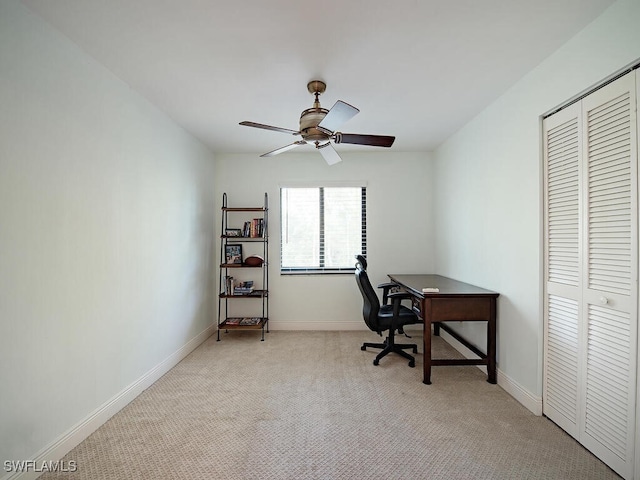 office area with ceiling fan, baseboards, and light colored carpet