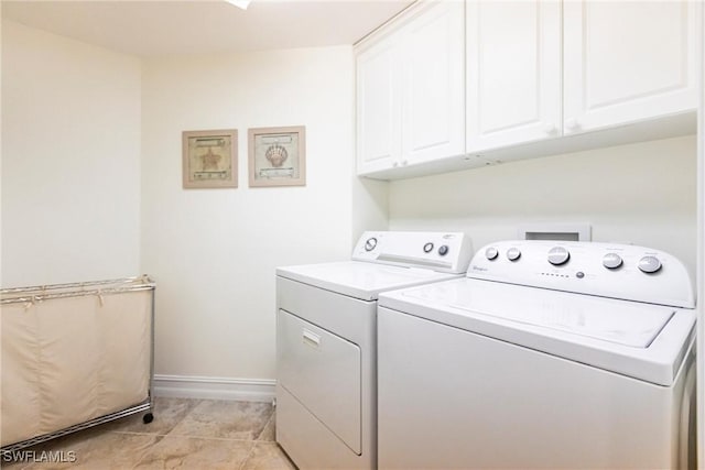washroom with cabinet space, washing machine and clothes dryer, baseboards, and light tile patterned flooring
