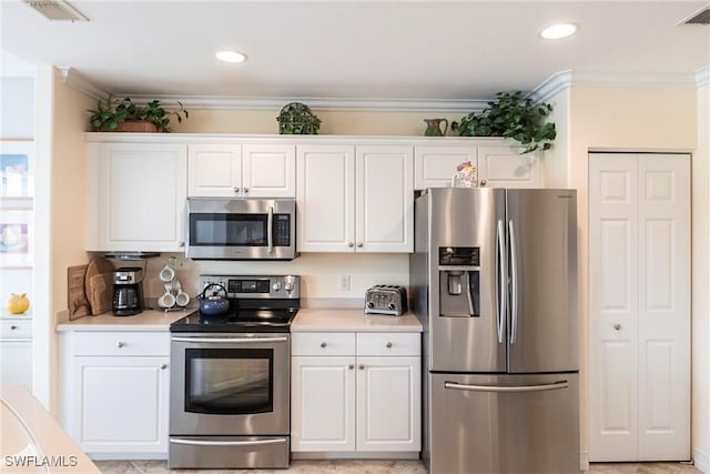 kitchen with white cabinets, stainless steel appliances, and light countertops