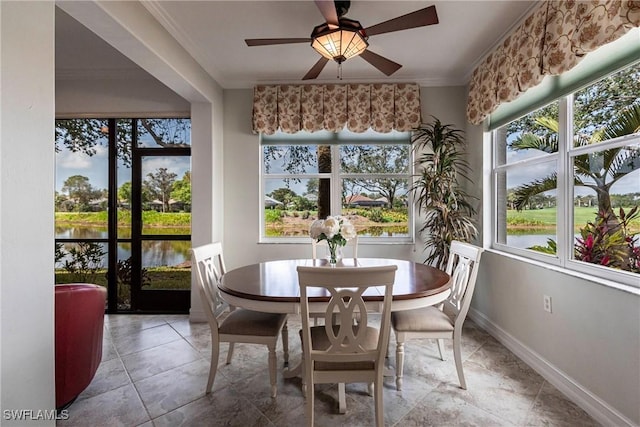 sunroom / solarium featuring a water view and ceiling fan