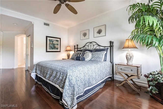bedroom featuring hardwood / wood-style flooring, visible vents, arched walkways, and crown molding