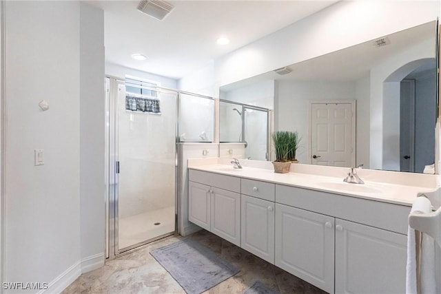 bathroom featuring double vanity, a sink, visible vents, and a stall shower