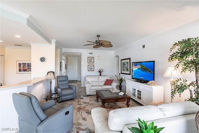 living room with ornamental molding, visible vents, and ceiling fan