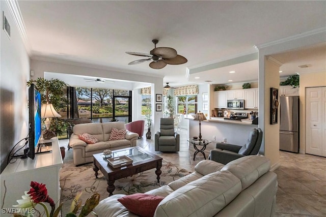 living area featuring a ceiling fan, a wealth of natural light, and crown molding