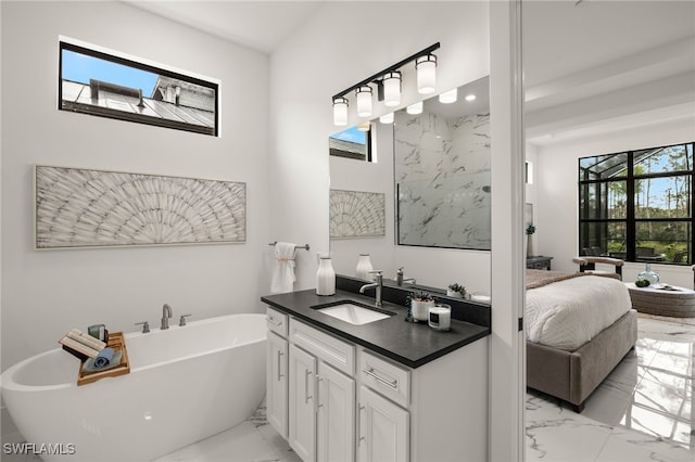 ensuite bathroom with a freestanding bath, marble finish floor, connected bathroom, and vanity