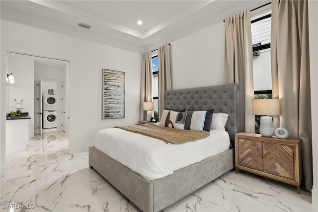 bedroom with marble finish floor, stacked washer / dryer, visible vents, and recessed lighting