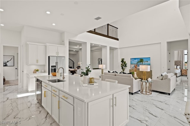 kitchen with light countertops, appliances with stainless steel finishes, a sink, and white cabinetry