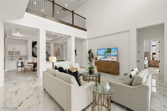 living area with marble finish floor, a high ceiling, stairway, and recessed lighting