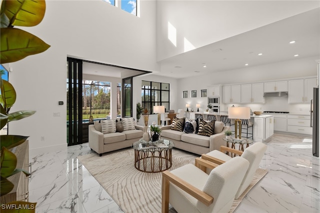 living area featuring marble finish floor, plenty of natural light, and recessed lighting