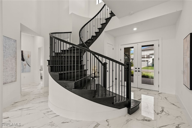 stairs featuring marble finish floor, a high ceiling, french doors, and recessed lighting