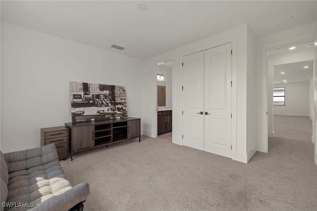 sitting room with light carpet, baseboards, and visible vents