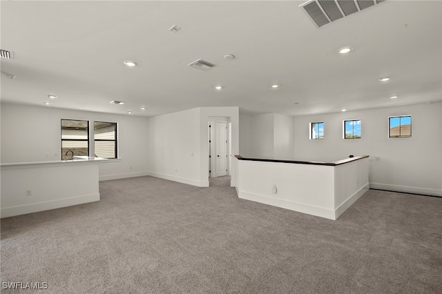 empty room with light colored carpet, visible vents, baseboards, and recessed lighting