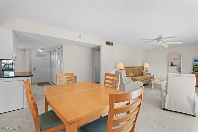 tiled dining space with ceiling fan