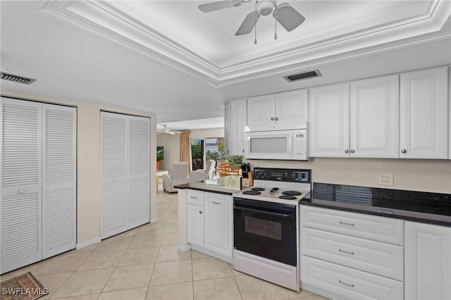 kitchen with a raised ceiling, range with electric cooktop, light tile patterned floors, and white cabinetry