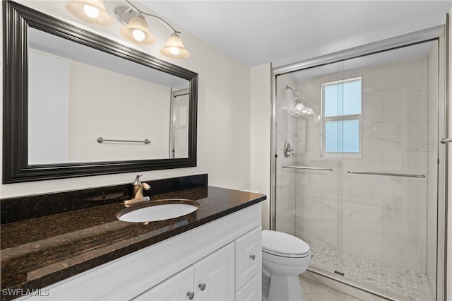 bathroom featuring vanity, toilet, and a shower with shower door