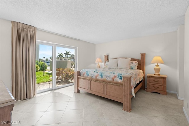 tiled bedroom featuring access to outside and a textured ceiling