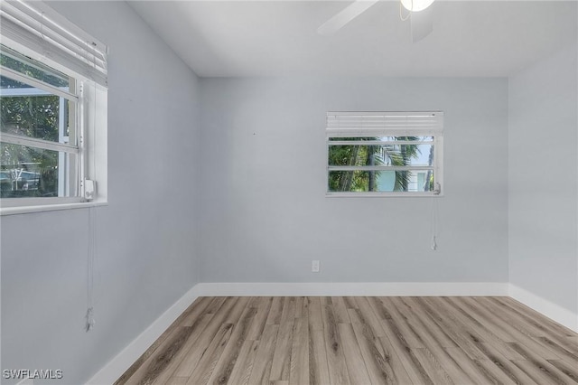 unfurnished room featuring a healthy amount of sunlight, baseboards, and wood finished floors