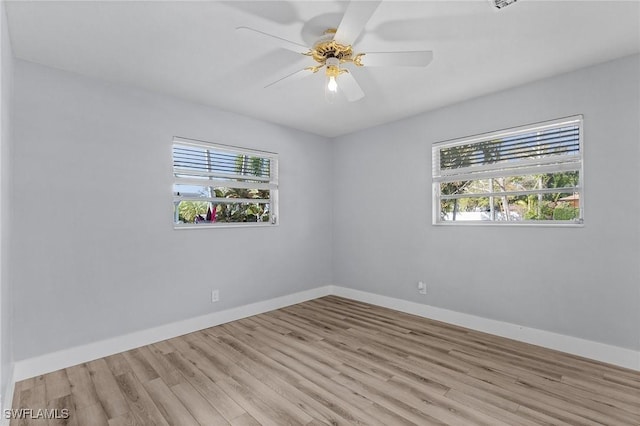 spare room with light wood finished floors, ceiling fan, and baseboards